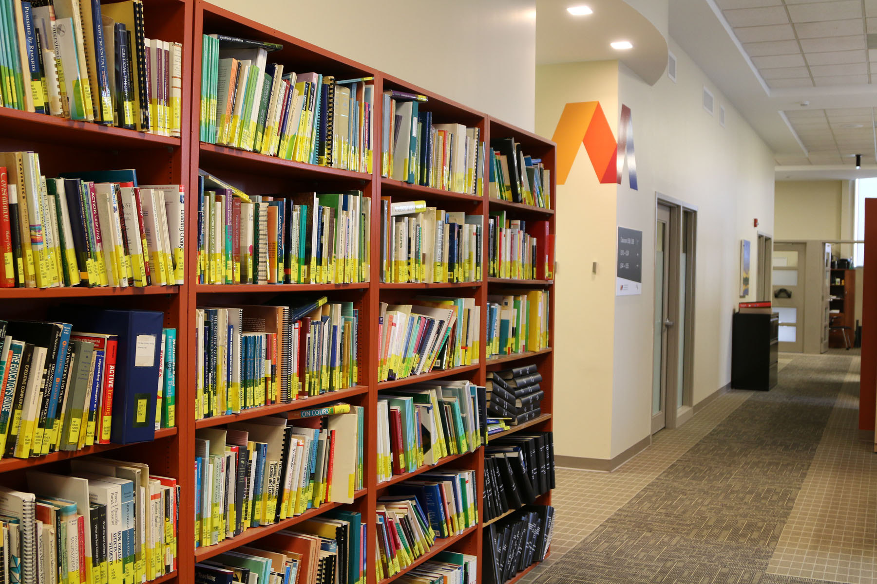Image shows hallway of offices at MacPherson as well as a bookshelf