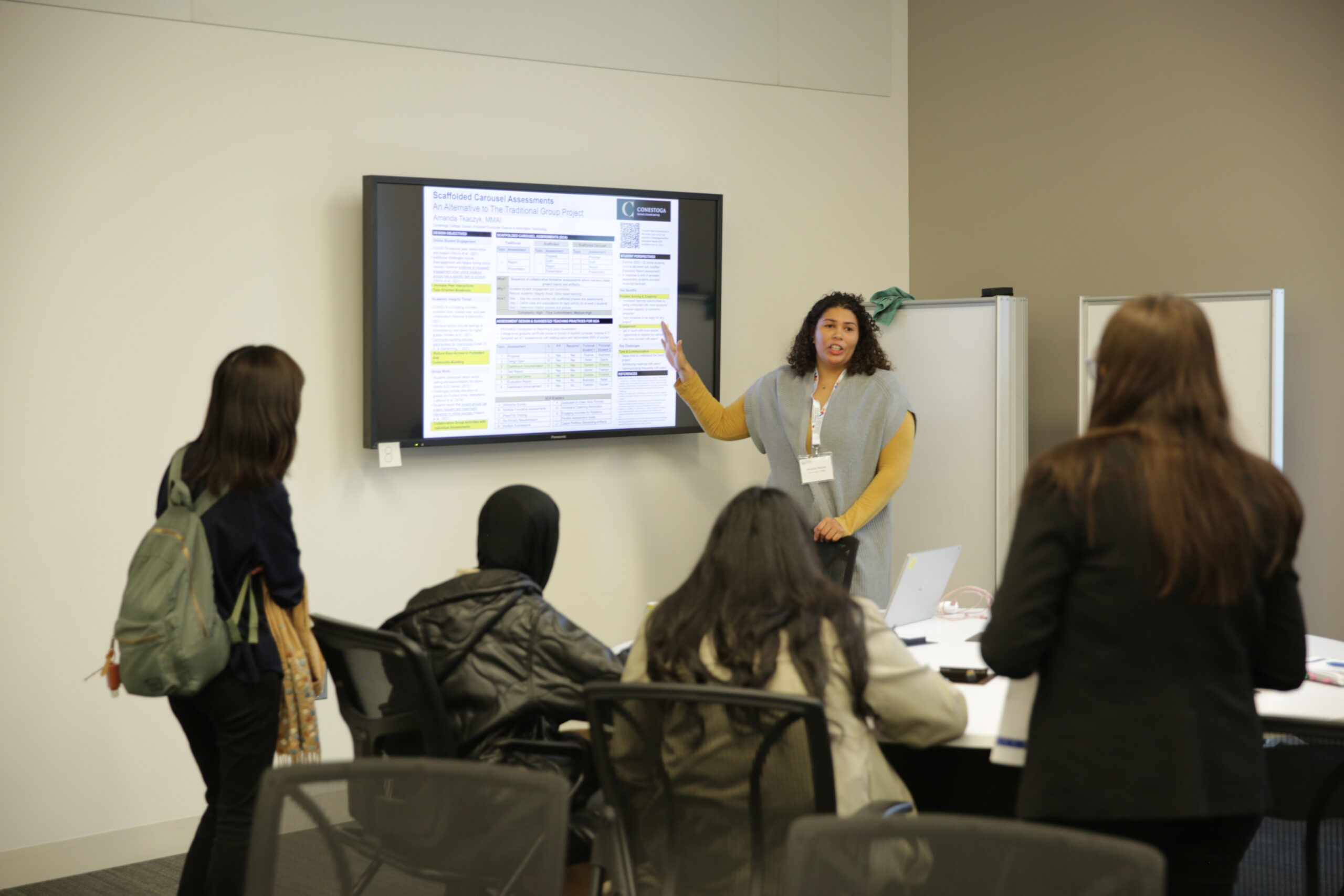 Instructor points at display monitor showing presentation